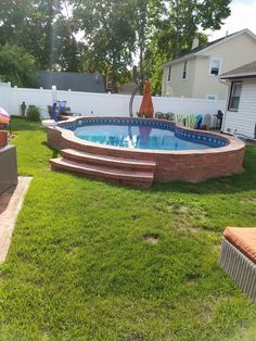 an above ground pool surrounded by lawn furniture and landscaping equipment in a backyard area with grass