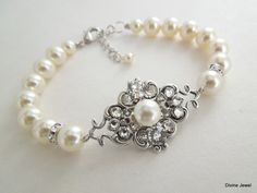 "This charming bracelet has antique silver filigree decorated with Austrian crystals and an Austrian pearl in the center by hand.  Filigree measures just under 1 1/2\" by 7/8\" at its widest point and it's been decorated with different shapes and sizes of Austrian crystals and pearls.  Strung pearls measure 8 and 6 mm and are accented with rhinestone roundelles. Finished off with a lobster clasp and 1\" extender for additional length.  Bracelet is approximately  7 1/2\" long. Size can be adjusted and pearls substituted with cream pearls.  Let me know at check out your preference of color and if you need me to adjust the size. **Listing is for bracelet only, please see links below for matching pieces Coordinating necklace, https://www.etsy.com/listing/124297852/pearl-necklacebridal-necklace Elegant Pearl Bracelet For Wedding With Intricate Design, Elegant Pearl Bracelet With Intricate Design For Wedding, Elegant Wedding Pearl Bracelet With Intricate Design, Vintage Silver Pearl Bracelets, Vintage Pearl Bracelet For Wedding, Vintage Silver Pearl Bracelet, Bridal Pearl Bracelet, Bridal Pearl Jewelry, Charming Bracelet