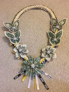 a necklace made out of dollar bills and ribbons