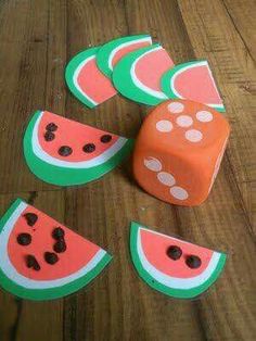 some dices and pieces of watermelon on a wooden table