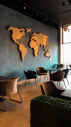 a room with chairs, tables and a world map on the wall