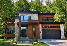 a large house with lots of windows in the front yard and trees on both sides