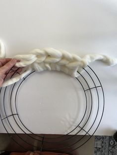 someone is making a piece of art out of yarn