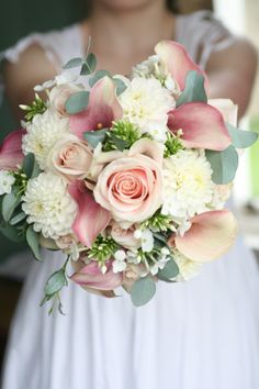 a bride holding a bouquet of flowers in her hands