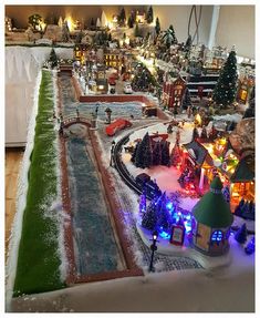 a model train set is shown with christmas lights and trees in the background on display