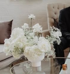 a man and woman sitting at a table with flowers in vases on the side