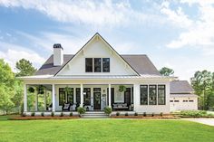 a white house sitting on top of a lush green field