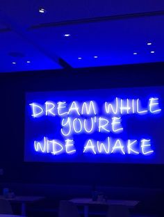 a neon sign that reads, dream while you're wide awake on the wall