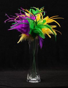 a vase filled with colorful feathers on top of a table