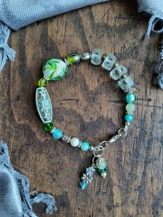 "Beaded bracelet in aqua and green tones of glass and vintage acrylic beads, and metallic silver accents. The length is 9.25\" up to 10\" (23.5 to  a little over 25 cm). Let me know if you would have it shorter (less beads near the clasp), I'll be glad to accommodate." Aqua And Green, Green Beaded Bracelets, Green Beaded Necklace, Peridot Earrings, Puka Shell, Green Copper, Garnet Earrings, Jade Bracelet, Dragon Pendant