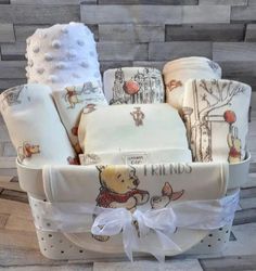 winnie the pooh baby gift basket with white blankets and swaddles in it