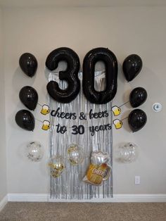 balloons and streamers are hanging from the wall in front of an 30th birthday banner