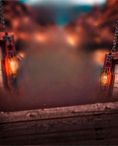 two red lanterns hanging from chains with lights on them