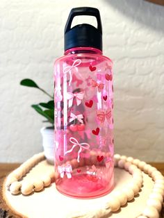 a pink water bottle sitting on top of a wooden table