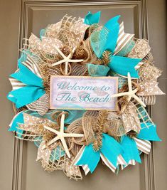 a welcome to the beach wreath with starfishs and burlocks on it