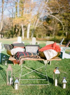 a picnic table with blankets and lanterns on it