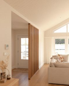 a living room filled with furniture and lots of windows on top of wooden flooring