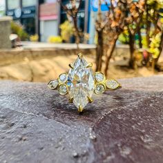 a yellow and white diamond ring sitting on top of a rock