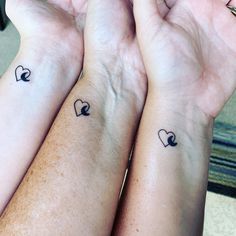 two people holding their hands together with tattoos on the wrist and heart in the middle