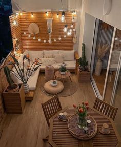 an overhead view of a living room and dining area with lights strung from the ceiling