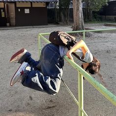 a young boy hanging upside down on a rail