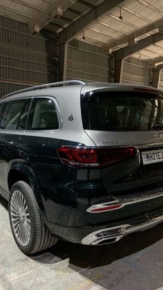 the rear end of a black car parked in a garage