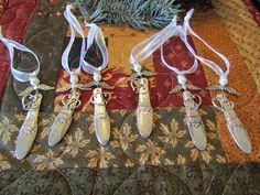 five silver christmas ornaments are hanging on a quilt