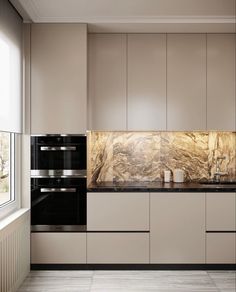 a kitchen with white cabinets and black counter tops, along with marble backsplash