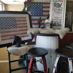 three stools are sitting in front of an american flag and other patriotic art on the wall