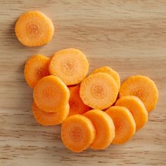 sliced up carrots sitting on top of a wooden table