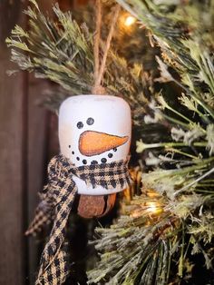 a snowman ornament hanging from a christmas tree