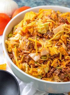 a white bowl filled with taco salad and tortilla chips