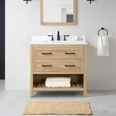 a bathroom with a sink, mirror and towel rack on the wall next to it