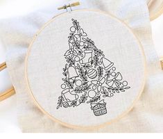 a cross - stitch christmas tree with presents on it is shown in black and white