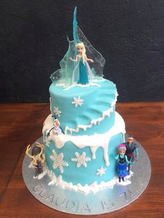 a frozen princess cake with figurines on top