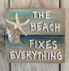 a wooden sign that says the beach fixes everything with a seashell on it