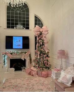 a living room decorated for christmas with a pink tree and decorations on the fireplace mantel