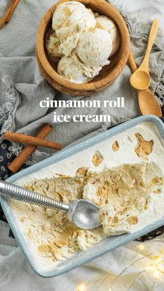 two scoops of ice cream sit in a bowl next to cinnamon sticks and spoons