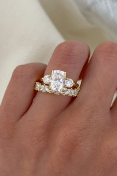 a woman's hand with two rings on it and one diamond ring in the middle