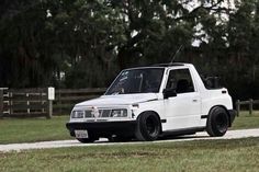 a white pick up truck driving down a road