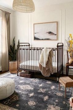 a baby crib in the corner of a room with a painting on the wall