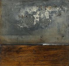 an old metal plate with rusted paint on it's sides and wood planks