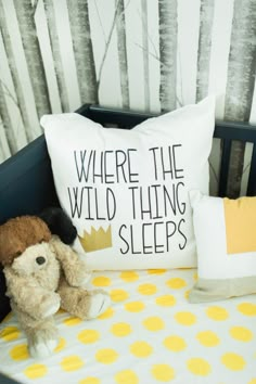 a stuffed animal sitting on top of a bed next to a pillow that says where the wild thing sleeps