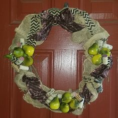 a wreath made out of burlocks with apples and other things on the front door