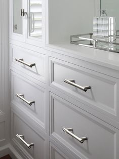 a white dresser with several drawers and a mirror