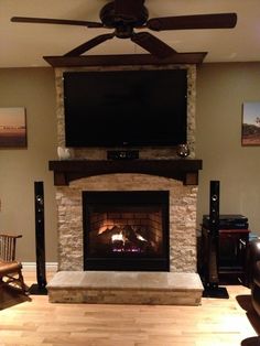 a living room with a fireplace and flat screen tv on the wall over the fire place