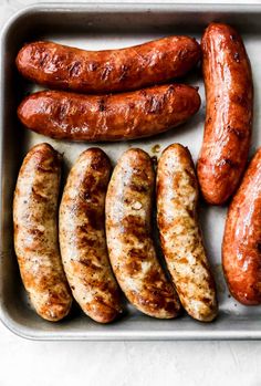 several sausages in a metal pan on a table