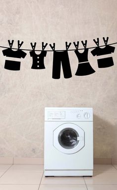 an image of clothes hanging on a line above a washer and dryer in the kitchen