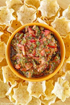 a bowl filled with salsa surrounded by tortilla chips