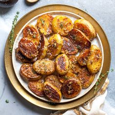 roasted potatoes on a plate with herbs